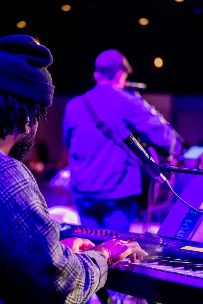 Crafting Captivating Headlines: Your awesome post title goes here Colorful live music scene featuring a pianist and guitarist on stage with vibrant lighting.