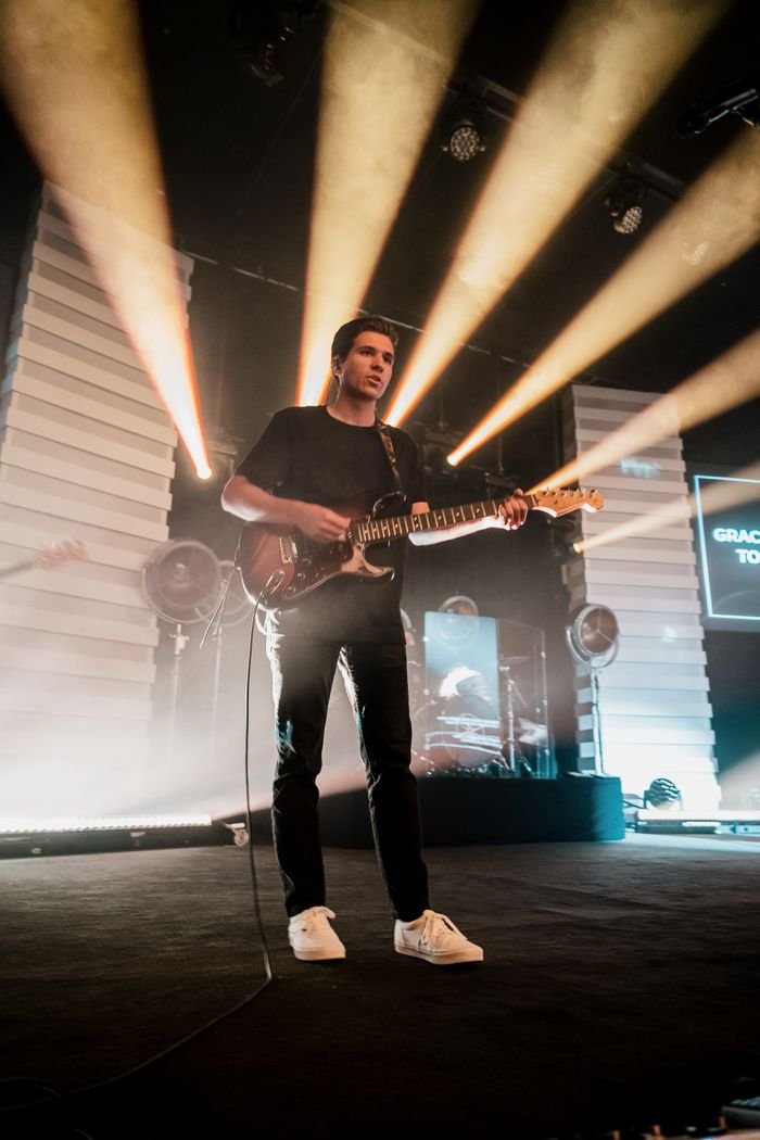 Mastering the First Impression: Your intriguing post title goes here A guitarist passionately playing electric guitar under bright stage lights during a live concert.